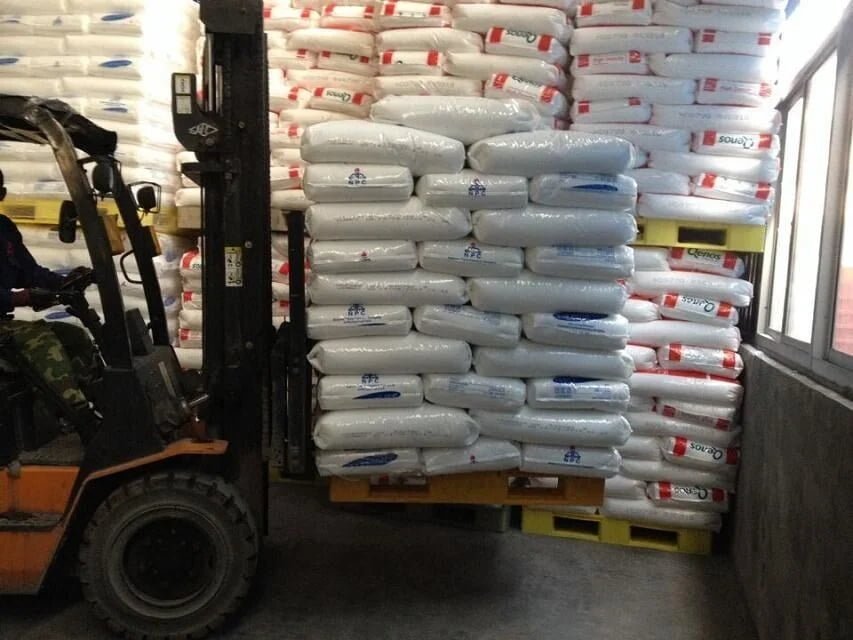 Forklift moving bagged goods on a full perimeter plastic pallet